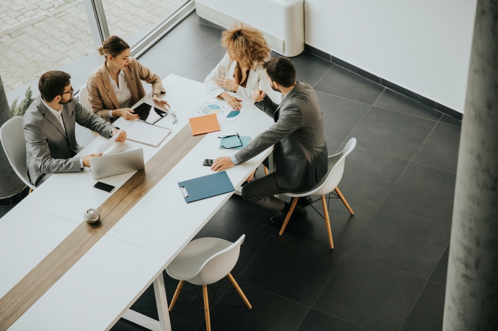 Four people meeting around a conference table